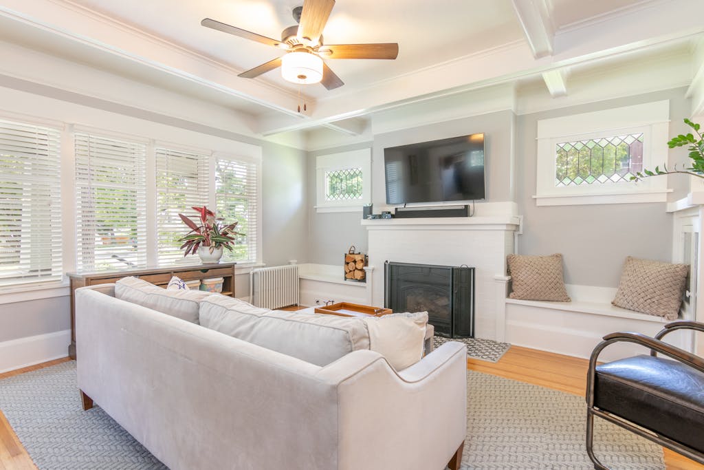 Elegant gray-themed living room featuring a cozy sofa, TV, and natural lighting.