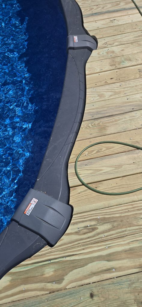Close-up of custom-cut wooden deck boards meeting the edge of an above-ground pool