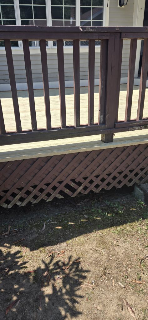 Repaired deck edge sitting above brown wooden lattice skirting after a resurfacing job